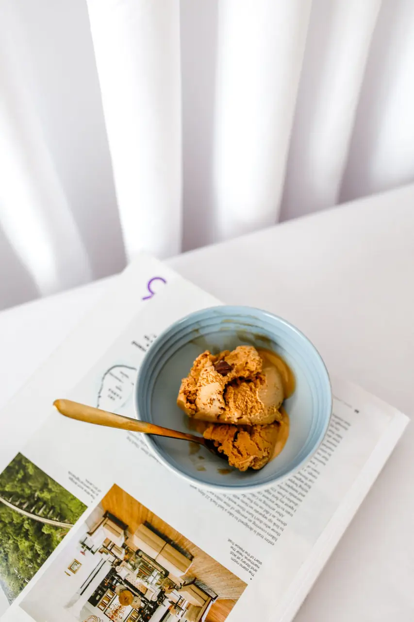 Artisan mango ice cream scoop in a blue bowl